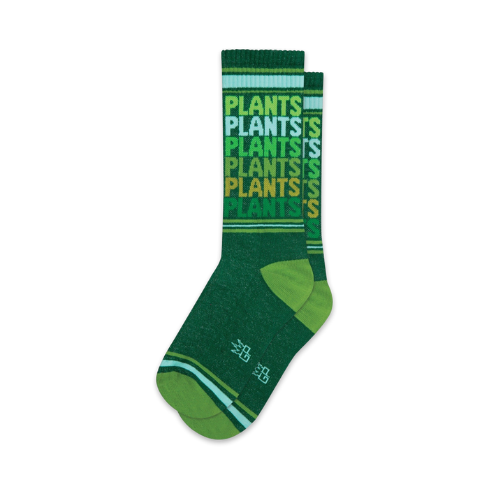 Pair of crew socks in various shades of green. The socks feature a repeating 'Plants' pattern and thin stripes at the top and bottom.