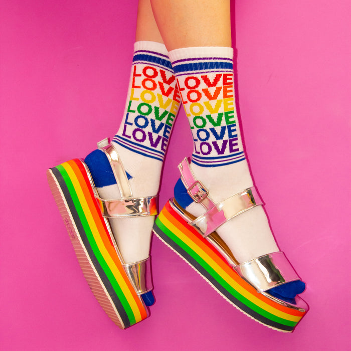 Flat lay of a pair of brown 'Love' socks on a yellow background.