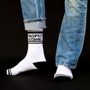 Lifestyle shot of Trophy Husband socks on a person's feet, shown with jeans rolled up.