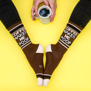 Flatlay product photo of the socks and a coffee mug on a yellow background.