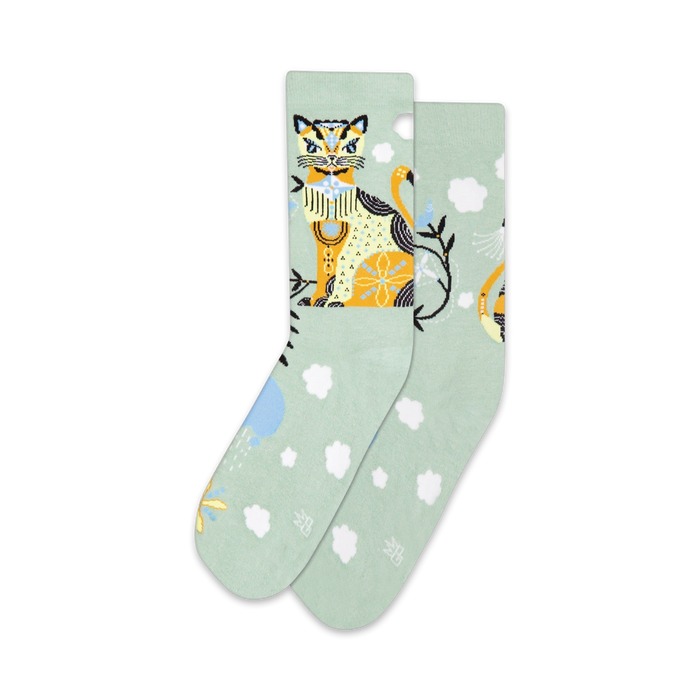 Pair of pastel green crew socks with a whimsical illustrated cat and cloud design. Yellow, orange, and white details.