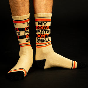 Lifestyle shot: A person's legs wearing the 'My Dog's Farts Don't Smell' socks against a black background.