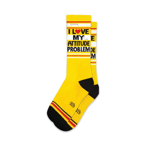 Pair of yellow crew socks with black and red stripes and the text 'I LOVE MY ATTITUDE PROBLEM'.