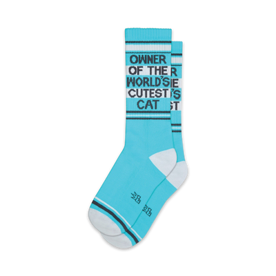 Pair of teal crew socks with a black graphic that reads 'Owner of the World's Cutest Cat'. White accents on the cuffs and toes.