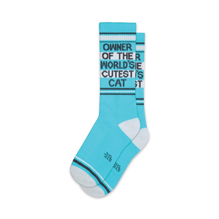 Pair of teal crew socks with a black graphic that reads 'Owner of the World's Cutest Cat'. White accents on the cuffs and toes.