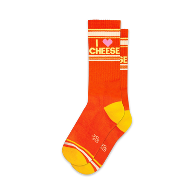 Pair of orange crew socks with yellow stripes and an 'I love cheese' graphic. Pink heart detail.