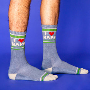 Lifestyle shot of a person wearing the 'I Love Naps' crew socks against a blue background.