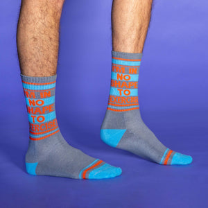 A pair of gray socks with blue and orange stripes at the top and the words 