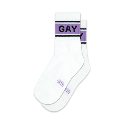 Pair of white crew socks with a lavender and black band reading 'GAY'.