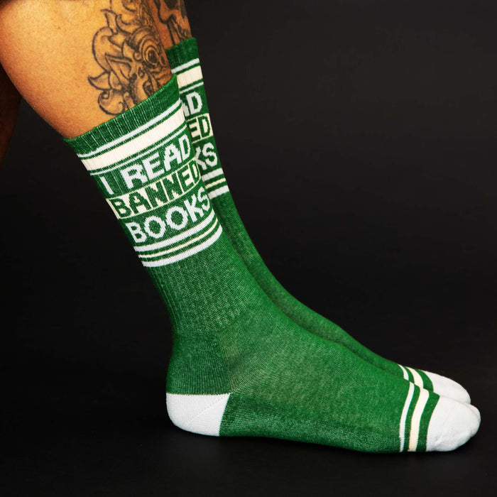 Lifestyle shot showing the 'I Read Banned Books' socks on a person's legs against a black background.