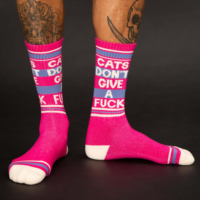 Lifestyle shot: Person wearing the pink 'Cats Don't Give A Fuck' crew socks. Shows the socks on the legs and the fit.