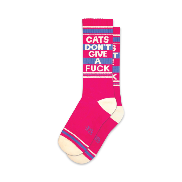Pair of pink crew socks with a blue 'Cats Don't Give A Fuck' slogan.  Features white and blue stripes at the top and bottom.