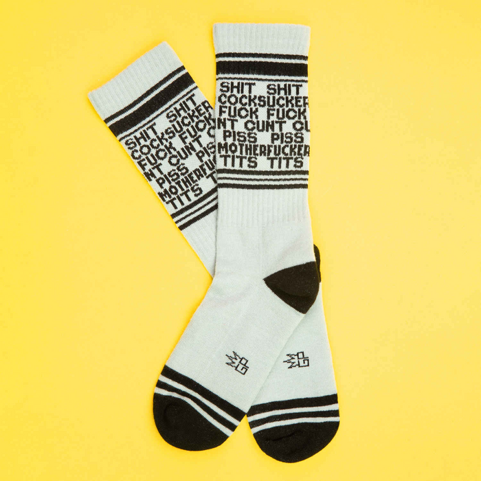 Pair of 'Dirty Words' socks laid flat on a yellow background, showcasing the design.