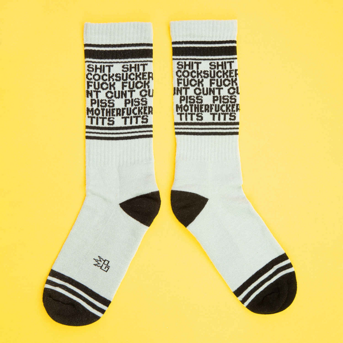 A flat lay showcasing two 'Dirty Words' socks on a yellow background.