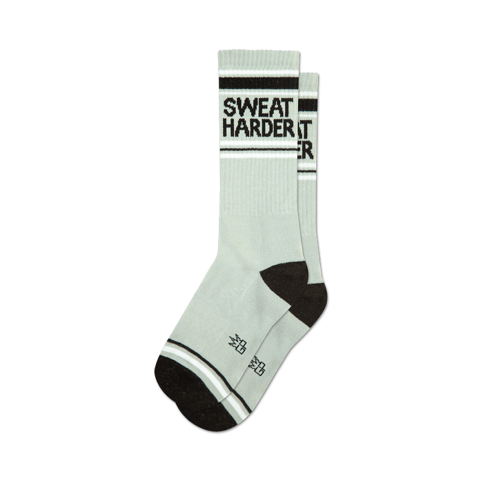 Pair of sage green crew socks with black 'Sweat Harder' text and black and white stripes at the top and bottom. }}