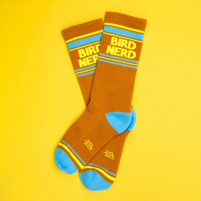 Flat lay of Bird Nerd socks on a yellow background.