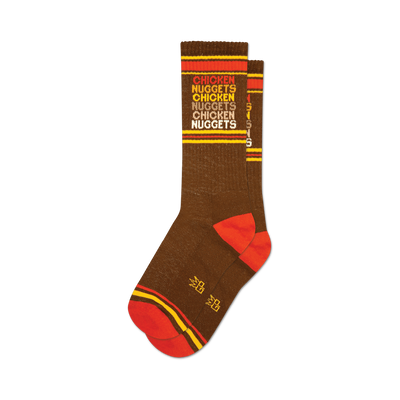Pair of brown crew socks with orange and yellow stripes and repeating 'Chicken Nuggets' text.