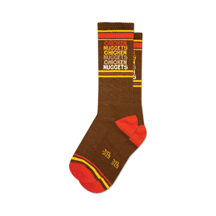 Pair of brown crew socks with orange and yellow stripes and repeating 'Chicken Nuggets' text. }}