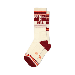Pair of cream crew socks with burgundy and orange stripes and the phrase 'See You In Hell' in burgundy lettering.