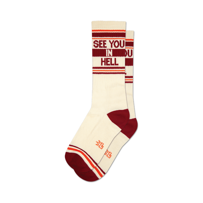 Pair of cream crew socks with burgundy and orange stripes and the phrase 'See You In Hell' in burgundy lettering.
