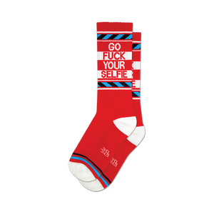 Pair of red crew socks with a bold 'Go Fuck Your Selfie' message in white and blue. Features blue and white stripes.
