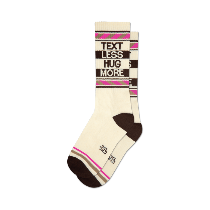 socks that are white with brown and pink stripes. the words 'text less hug more' are written on the front of the socks in brown and pink letters. }}