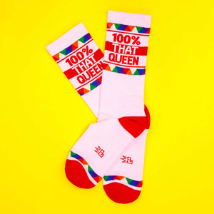 Flat lay of '100% That Queen' socks on a yellow background.