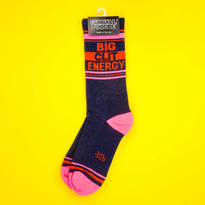 'Big City Energy' socks displayed on a yellow background still on the original packaging.