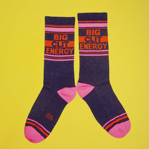 Lifestyle shot showing one 'Big City Energy' sock casually arranged on a yellow background.