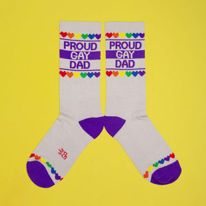 Close-up detail shot of the 'Proud Gay Dad' sock design, showcasing the rainbow hearts and text.