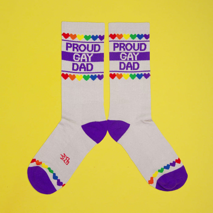 Close-up detail shot of the 'Proud Gay Dad' sock design, showcasing the rainbow hearts and text.