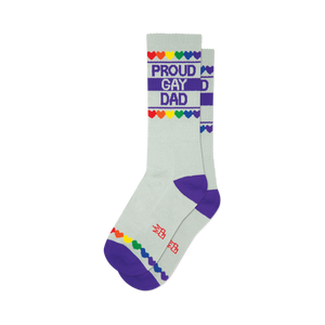 Pair of light grey crew socks with purple cuffs. Design includes 'Proud Gay Dad' text and rainbow hearts.