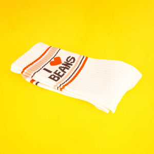 Folded 'I Heart Beans' sock on a yellow background.