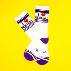 Flatlay of 'I Heart Pickleball' socks on yellow background.