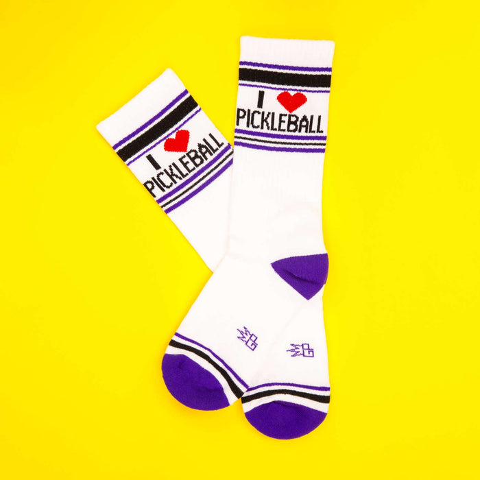 Flatlay of 'I Heart Pickleball' socks on yellow background.