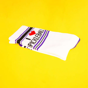 Close-up of folded 'I Heart Pickleball' sock on yellow background.