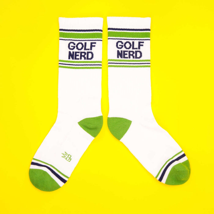 Another flatlay image of Golf Nerd socks, laid out differently, against a yellow backdrop.