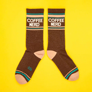 Flatlay of a pair of brown Coffee Nerd socks laid out on a bright yellow background.