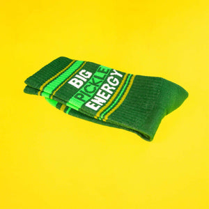 A folded green 'Big Pickle Energy' sock on a bright-yellow background.