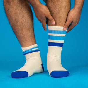 Lifestyle shot: Person's legs wearing the Alice socks, showcasing fit and style against a blue backdrop.