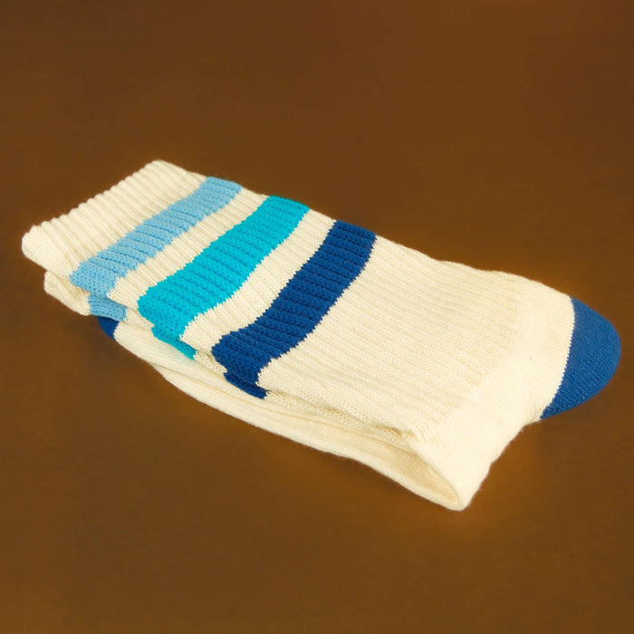 Folded socks: A folded pair of Alice socks on a brown surface, emphasizing texture and color.