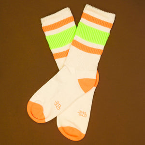 Flat lay: Pair of Bobby socks on a brown background, showcasing the design details and color.