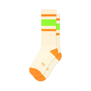 Pair of off-white crew socks with orange and neon green stripes. Orange accents at the toe and heel.  Retro style.