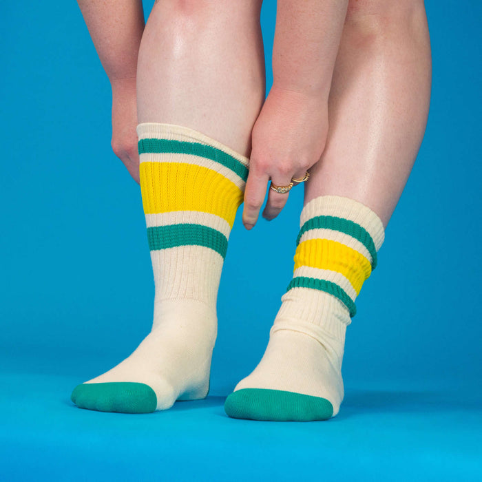 Lifestyle shot of Carol socks on a person's legs against a bright blue background.