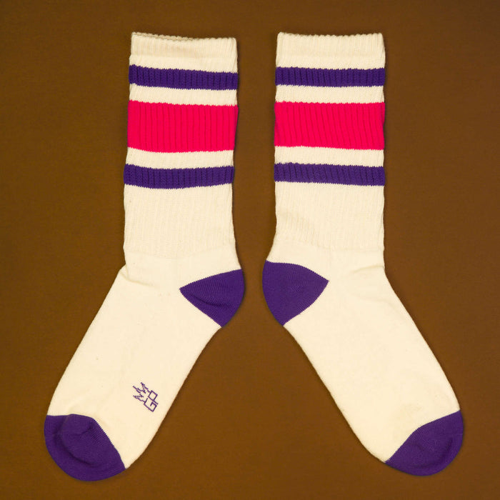 Flat lay: A pair of Jan socks laid flat on a dark brown surface, showcasing the design detail.