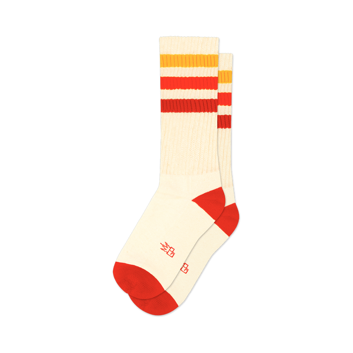Pair of cream crew socks with red, orange, and yellow horizontal stripes. Red accents at the heel and toe. Small logo on the bottom.
