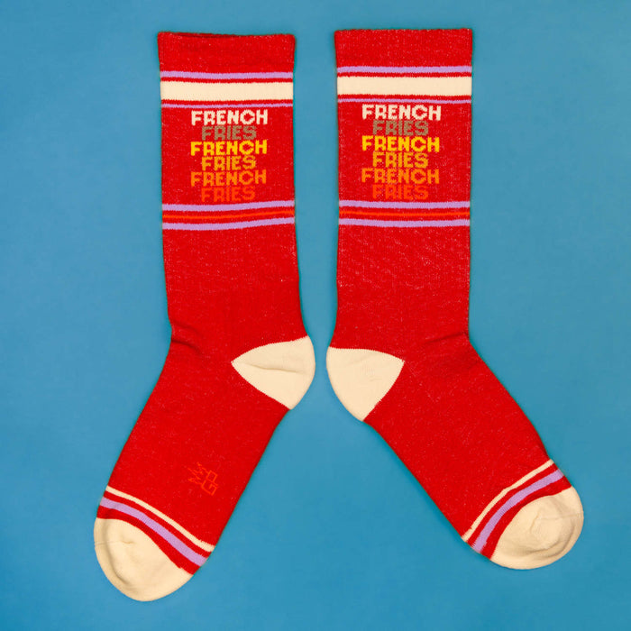 Flatlay image of two 'French Fries' socks laid out on a blue background.