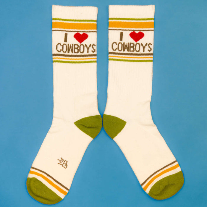 Another flat lay of 'I love cowboys' socks against a blue background, displayed differently.