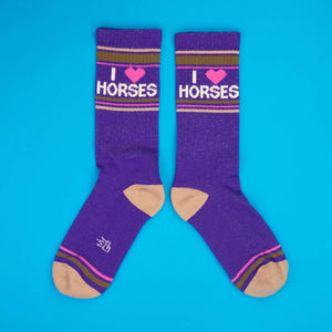 Another flatlay showcasing the purple 'I Heart Horses' socks against a blue backdrop.