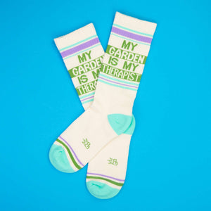 Lifestyle shot of 'My Garden Is My Therapist' socks on a bright blue background.